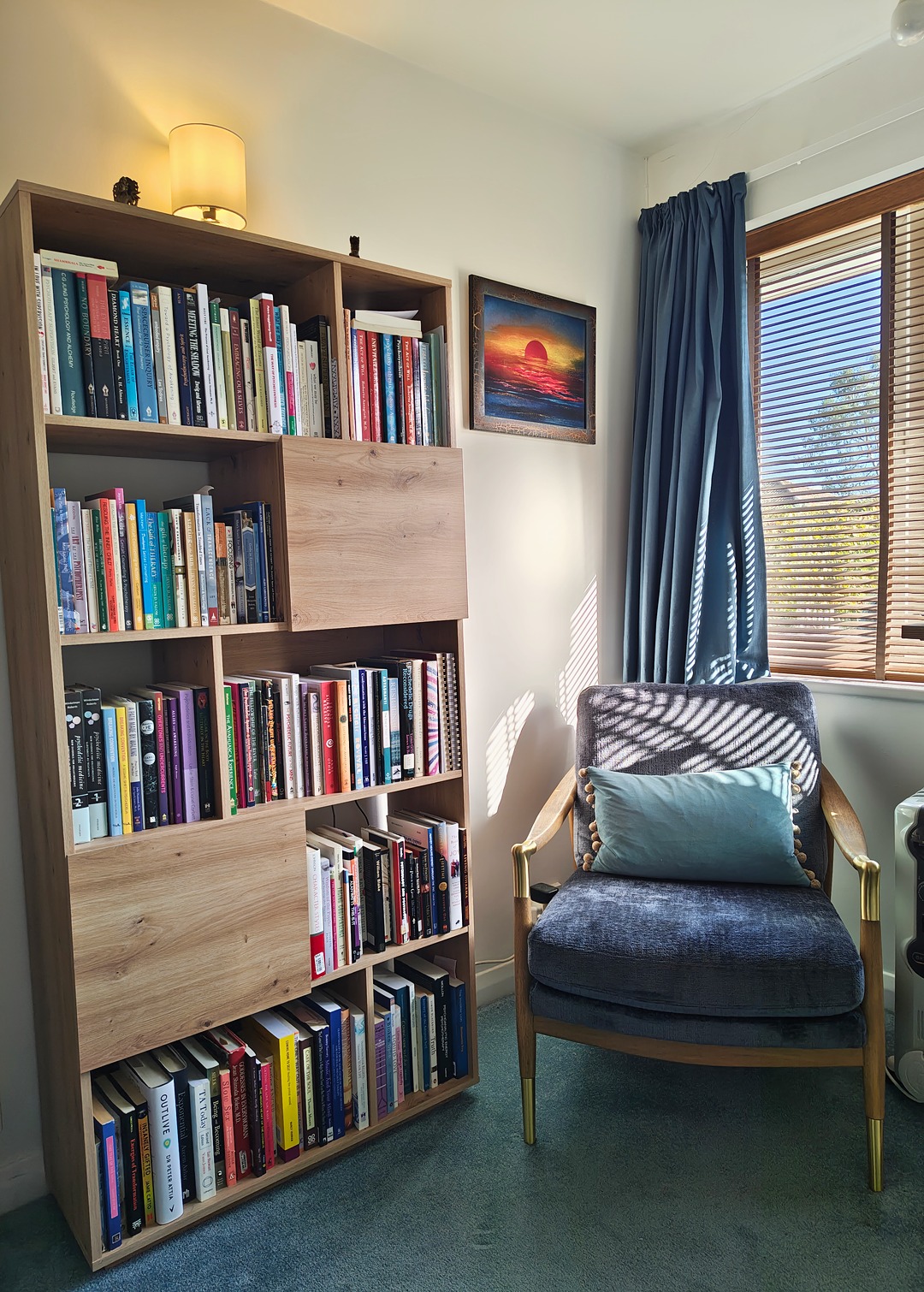 thomas-shutte-therapy-room-chair-gbp Therapy room with armchair, bookcase and sunset painting, Thomas Shutte psychotherapist